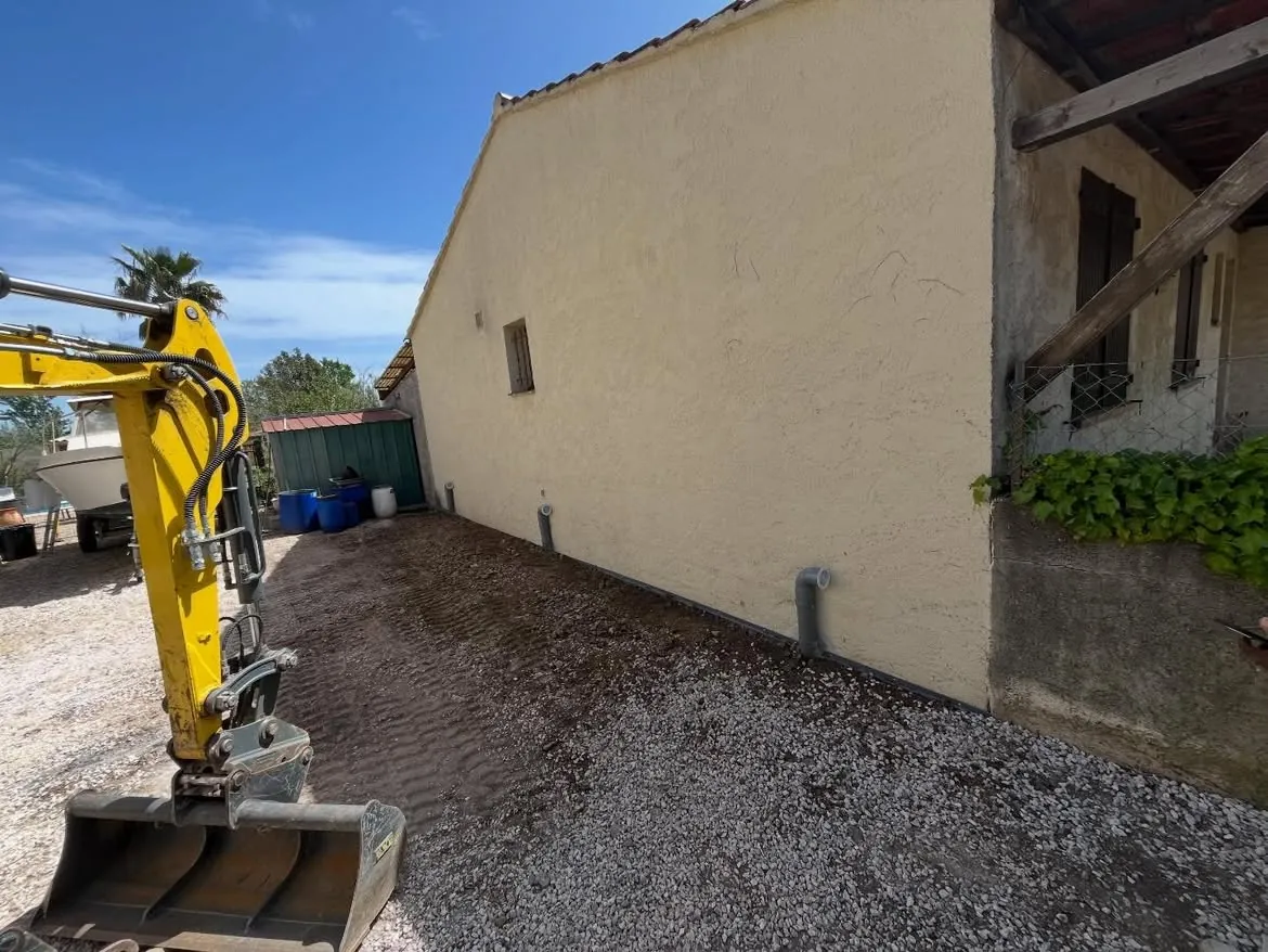 Remblayage au pied de la façade avec la minipelle à La Farlède