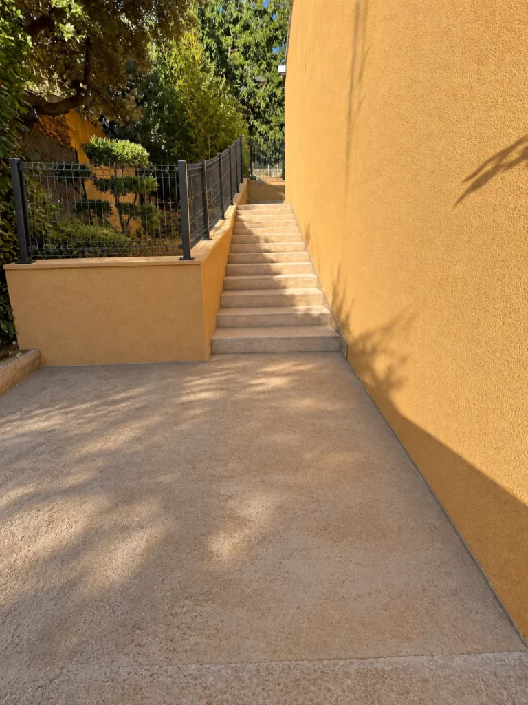Escalier fini avec mur enduit et clôture rigide, vue du bas à Méounes